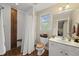 Well-lit bathroom featuring a modern shower with a curtain, toilet, vanity, and a window providing natural light at 85 Rivers Edge Ct, Timberlake, NC 27583