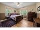 Comfortable bedroom with hardwood floors, two windows and a warm, inviting atmosphere for relaxation and rest at 85 Rivers Edge Ct, Timberlake, NC 27583