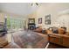 Spacious living room featuring a stone fireplace, hardwood floors, and comfortable leather furniture at 85 Rivers Edge Ct, Timberlake, NC 27583