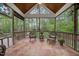 Screened in porch featuring tile floors, seating, and wooded views at 85 Rivers Edge Ct, Timberlake, NC 27583
