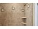 Close up of beige tile shower with sea life decorations on some of the tiles with built-in corner shelving at 85 Rivers Edge Ct, Timberlake, NC 27583