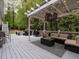 A well appointed deck features a covered lounge area and a grill for enjoying the outdoors at 8805 Stage Ford Rd, Raleigh, NC 27615