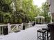 Wide angle of the back deck featuring a dining table, grill, and covered lounge area with string lights at 8805 Stage Ford Rd, Raleigh, NC 27615