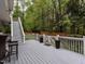 This back deck has stairs and a gate leading to the back yard and lounge furniture nearby at 8805 Stage Ford Rd, Raleigh, NC 27615