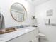 Bathroom featuring a white vanity with marble countertop and round mirror at 8805 Stage Ford Rd, Raleigh, NC 27615