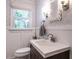 Charming powder room with decorative wallpaper, wainscoting, and a stylish sink with modern fixtures at 8805 Stage Ford Rd, Raleigh, NC 27615