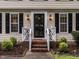 Close-up of a front door with decorative railings, lanterns, and manicured landscaping at 8805 Stage Ford Rd, Raleigh, NC 27615