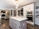 Modern kitchen with white cabinets, an island, and built-in stainless steel appliances, open to the living room at 8805 Stage Ford Rd, Raleigh, NC 27615