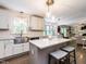 Bright kitchen features an island, stainless steel sink, and modern pendant lighting at 8805 Stage Ford Rd, Raleigh, NC 27615