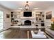 Bright living room featuring a brick fireplace, built-in shelving, and hardwood floors at 8805 Stage Ford Rd, Raleigh, NC 27615