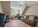 Finished bonus room with light laminate flooring, a brown suede couch, ceiling fan, and ample natural light at 9016 New Century Rd, Wake Forest, NC 27587
