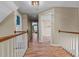 Hallway with wood floors and white railings, leading to multiple rooms at 9016 New Century Rd, Wake Forest, NC 27587