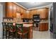 Well-lit kitchen with wooden cabinets, stainless steel appliances, and a breakfast bar, perfect for casual dining at 9016 New Century Rd, Wake Forest, NC 27587
