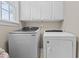 Bright laundry area with white washer and dryer, white cabinets and a window for natural light at 9016 New Century Rd, Wake Forest, NC 27587