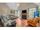Comfortable living room with a fireplace, a ceiling fan and large windows offering great natural light at 9016 New Century Rd, Wake Forest, NC 27587