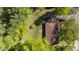 Aerial view of a brick house showcasing its roof, surrounding trees, driveway, and overall property layout at 906 Circle Dr, Creedmoor, NC 27522