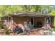 Brick back porch featuring rocking chairs, an ATV, and wrought iron details at 906 Circle Dr, Creedmoor, NC 27522
