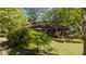Brick home surrounded by lush greenery, providing a sense of privacy and connection to nature at 906 Circle Dr, Creedmoor, NC 27522