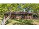 Inviting brick home featuring a cozy entrance and a well-manicured lawn, enhanced by the shade of mature trees at 906 Circle Dr, Creedmoor, NC 27522