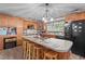 Functional kitchen with central island, a black fridge, and natural wood cabinets at 906 Circle Dr, Creedmoor, NC 27522