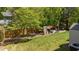 Well-maintained backyard featuring green lawn, wooden fence, mature trees, and outdoor shed at 9212 Linslade Way, Wake Forest, NC 27587