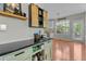 A built-in bar features wooden accents, a granite countertop, and a view into the kitchen at 9212 Linslade Way, Wake Forest, NC 27587