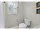 Cozy bathroom featuring a toilet with plush seat and a bright window with sheer curtains at 9212 Linslade Way, Wake Forest, NC 27587