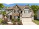 Charming two-story home featuring a stone facade, attached garage, and manicured landscaping at 9212 Linslade Way, Wake Forest, NC 27587