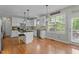 A bright kitchen with hardwood floors, a black island, white cabinets, and modern light fixtures at 9212 Linslade Way, Wake Forest, NC 27587