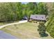 Inviting home with a long driveway and a detached garage, surrounded by lush landscaping and mature trees at 936 Elbridge Dr, Raleigh, NC 27603