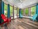 Sun room with vinyl plank floors, windows, fan, and red and blue Adirondack chairs at 936 Elbridge Dr, Raleigh, NC 27603
