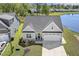 Aerial view of a charming home with a two car garage, landscaping, and lake views at 98 Buddy Campbell Ct, Angier, NC 27501