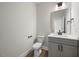 Clean half bathroom with grey vanity, white toilet, and neutral paint at 000 Olivia Pope Way, Efland, NC 27243