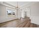 Open-concept dining room with hardwood floors and modern light fixture at 000 Olivia Pope Way, Efland, NC 27243