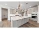 Modern kitchen features gray cabinetry, quartz counters, stainless appliances, and stylish pendant lighting at 000 Olivia Pope Way, Efland, NC 27243