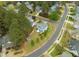 Aerial view of a blue house with a large yard, shed, patio, and mature trees at 101 Rustic Pine Ct, Apex, NC 27502