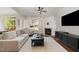 Bright living room with a ceiling fan, fireplace, and large windows that provide an abundance of natural light at 101 Rustic Pine Ct, Apex, NC 27502
