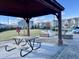 Inviting community space features a picnic table under a pergola and brick patio with fire pit and chairs at 1016 Mirbeck Ln, Durham, NC 27713