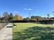 Fenced-in dog park with lush green artificial turf and benches, perfect for pets to play at 1016 Mirbeck Ln, Durham, NC 27713