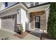 Welcoming front entrance with stone accents, a decorative wreath, and an attached garage at 1016 Mirbeck Ln, Durham, NC 27713