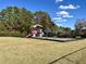 Community playground featuring a slide, swings, and play equipment surrounded by lush greenery at 1016 Mirbeck Ln, Durham, NC 27713