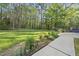 Expansive back yard with a pathway and a deck, surrounded by tall trees at 104 Arcadia Ln, Chapel Hill, NC 27514