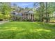 Beautiful brick home with grand columns, lush lawn, and mature trees creating a serene landscape at 104 Arcadia Ln, Chapel Hill, NC 27514