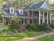 Charming brick home with dormers, columns, and lush greenery at 104 Arcadia Ln, Chapel Hill, NC 27514