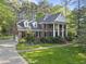 View of brick two-story home with white columns, attached garage, and manicured lawn at 104 Arcadia Ln, Chapel Hill, NC 27514