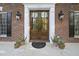 Elegant front entrance featuring wood doors, classic brick, and stylish outdoor lighting at 104 Arcadia Ln, Chapel Hill, NC 27514