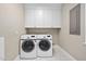 This laundry room offers washer, dryer, white cabinets and neutral paint at 104 Arcadia Ln, Chapel Hill, NC 27514