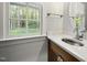 This powder room features marble countertop, wood cabinet and outdoor view through a large window at 104 Arcadia Ln, Chapel Hill, NC 27514