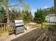 Well-maintained backyard deck with outdoor cooking area, seating and mature trees at 104 Hamby Ct, Garner, NC 27529