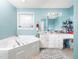 Bathroom with a large soaking tub, white cabinets and vanity, and an abundance of natural light at 104 Hamby Ct, Garner, NC 27529